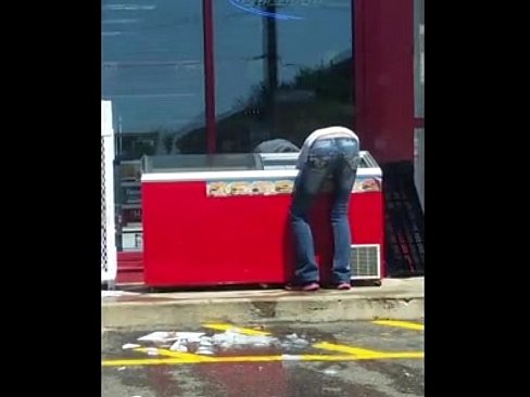 Gas Station Employee cleaning a cooler