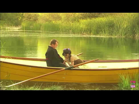 A slender young woman engages in sexual intercourse with a man's large penis while aboard a boat on a lake