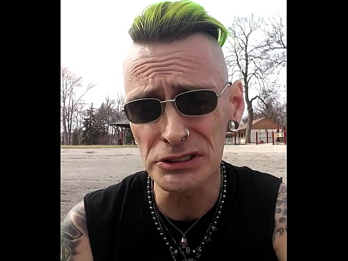 A punk rocker chillen in a park talkin about nothing important.