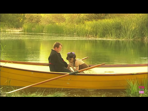 In the midst of a lake, a charming pair engaged in an outdoor activity on a compact watercraft