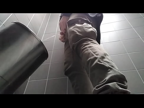 Uncut man peeing in a public toilet.