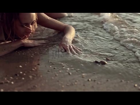 Russian model poses in wet tank top on the beach