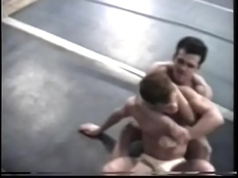 Muscular hunks throw and pin each other in wrestling ring