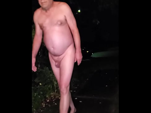 Nude old man walks into street at night