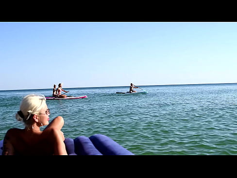 I spy on the beach as a girl with big boobs sunbathes in front of the public and dolphins