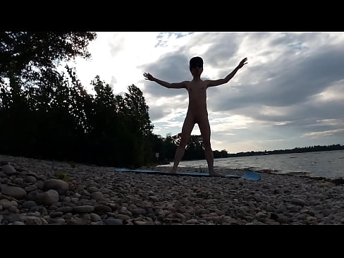 Skinny naturist twink practices naked yoga on a nudist beach
