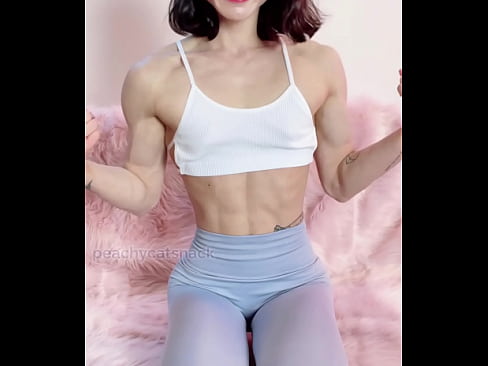 Nerdy, cute, and petite Asian muscle girl flexes in workout leggings