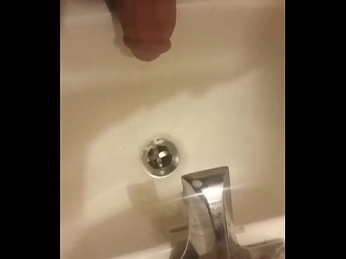 Guy peeing in sink by himself