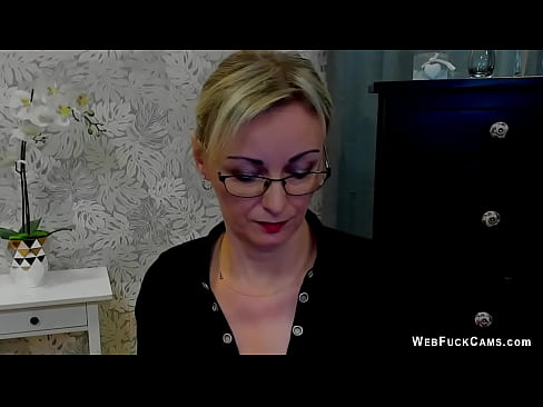 Blonde amateur German MILF LUXvanessa in glasses dressed in black blouse with a big cleavage posing and flashing nice pair of tits on solo webcam show
