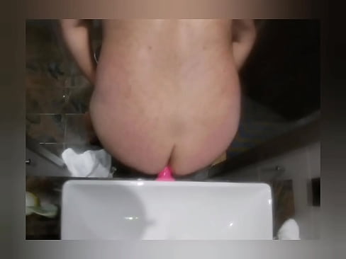 Toying ass with pink dildo in bathroom