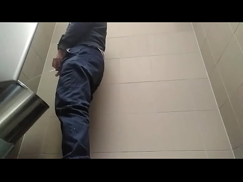 Young man peeing in a toilet