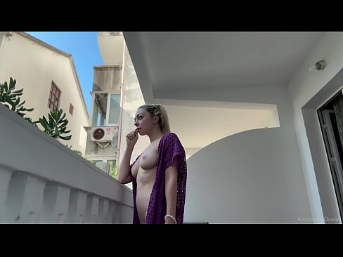 Flashing her tits on a public balcony.