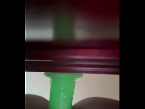 Sexy milf screwing big green dildo stuck onto bed base