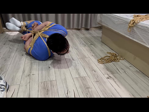 Hogtied Asian boy struggles