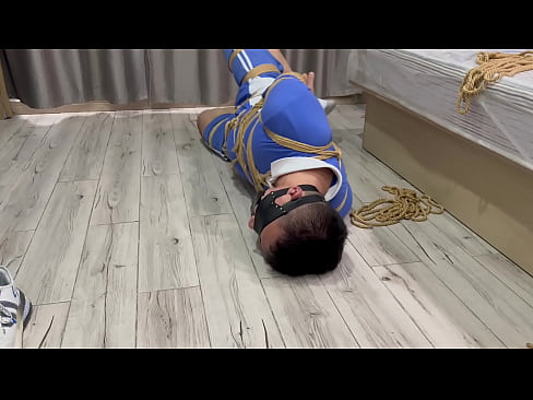 Hogtied Asian boy struggles