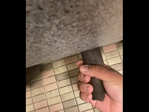 Giving a handjob to uncut BBC under a stall in a public bathroom