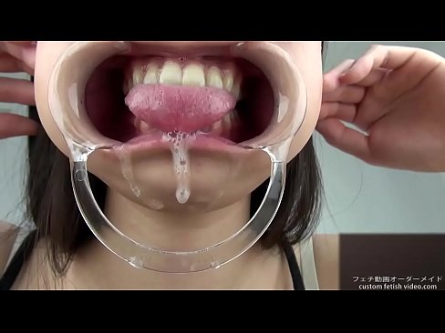 A woman shows her gums and sputs saliva