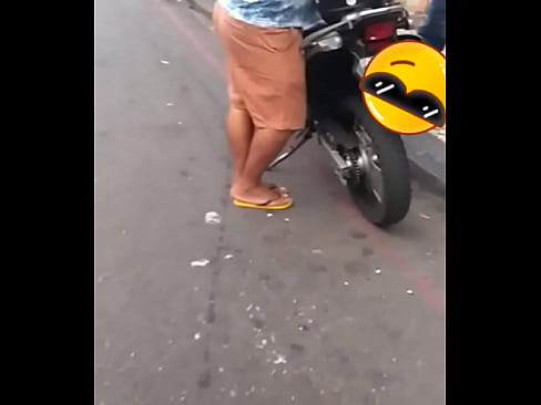 Dono da moto na avenida de camisa e bermuda