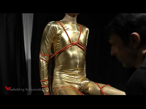 In this clip, Nicky is wearing a gold jumpsuit