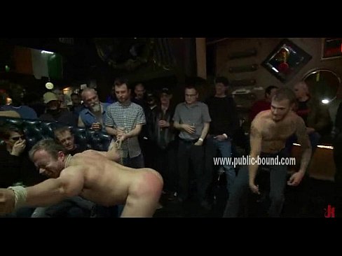 Stud is tied up in a bar and has his balls and torso covered in nipple clamps