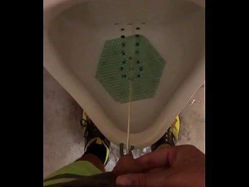 Male pisses in a urinal and thumbs dick