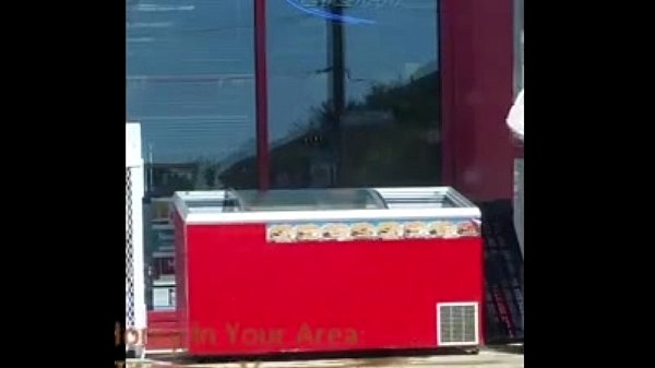 Gas Station Employee cleaning a cooler