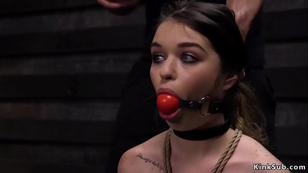 Eighteen years old Anastasia Rose bites ballgag and on her knees in rope bondage suffers whip then two masters fuck her