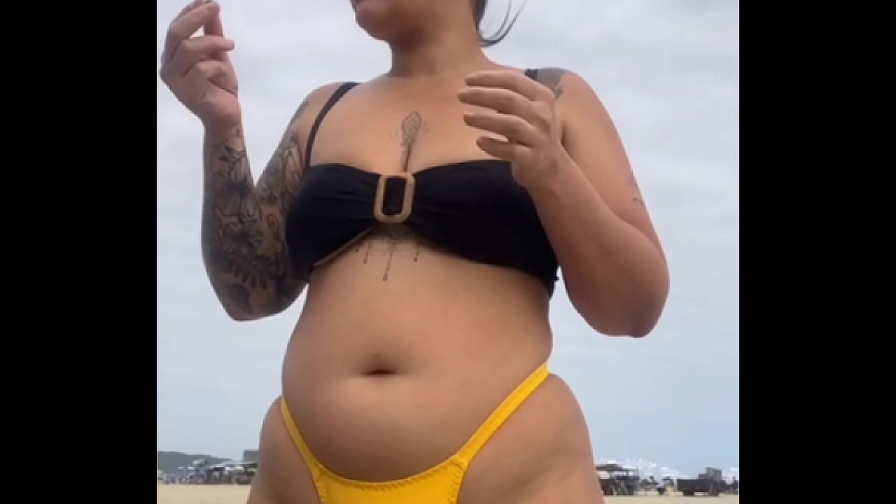 USANDO UM BIQUINI AMARELO BEM APERTADO RACHANDO A BUCETA PRA CHAMAR ATENÇÃO NA PRAIA