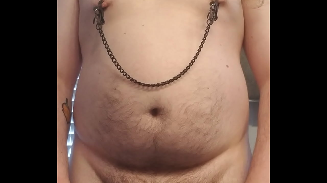 Chubby boy masturbating while tugging on nipple clamps