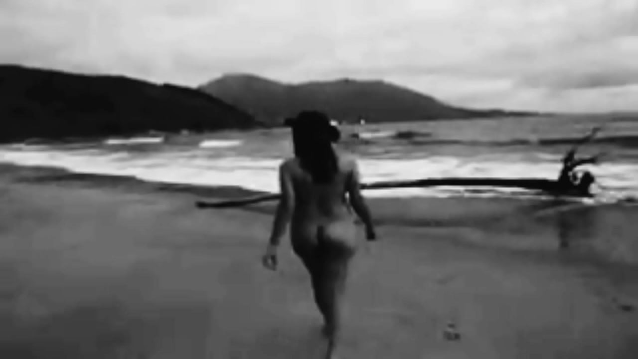 Mulher  peladinha posando na praia para o corno filmar