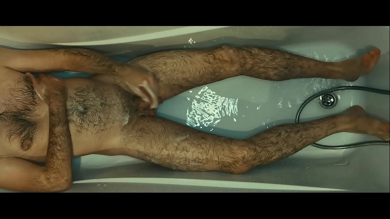 Hunk hairy man soaping himself and playing with urine in the white bath