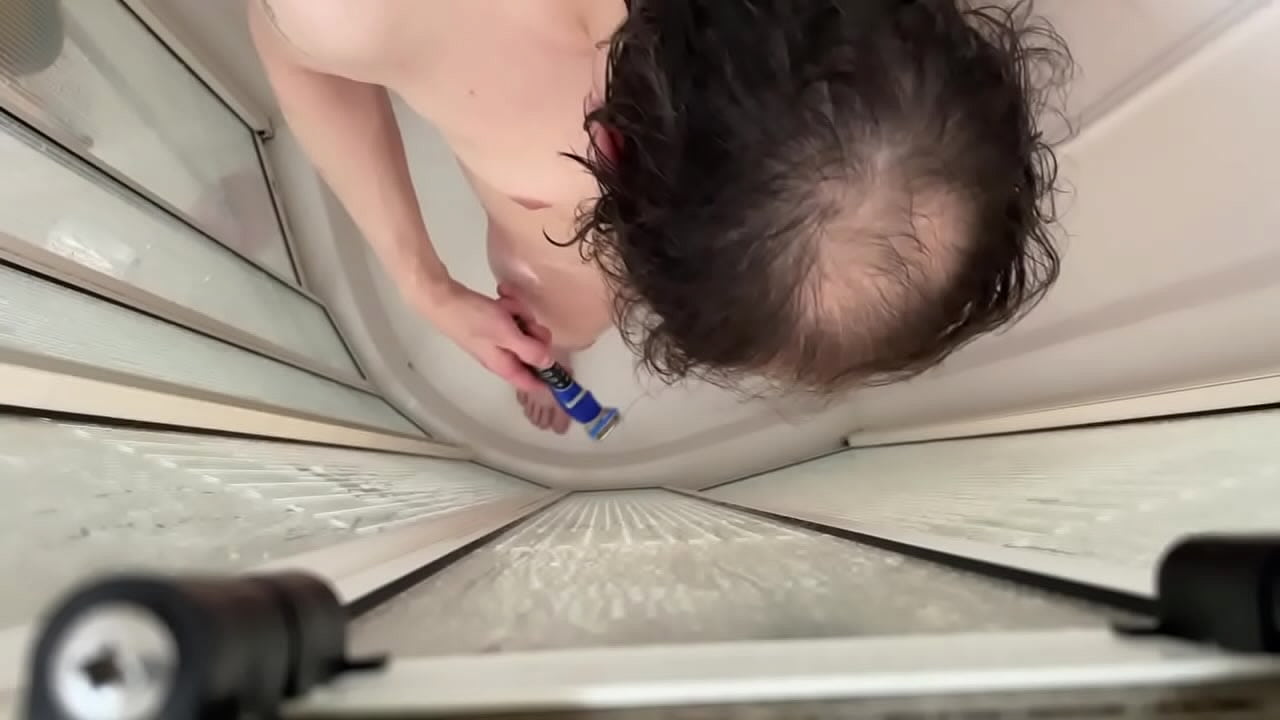 Garçon se rase dans sa douche.