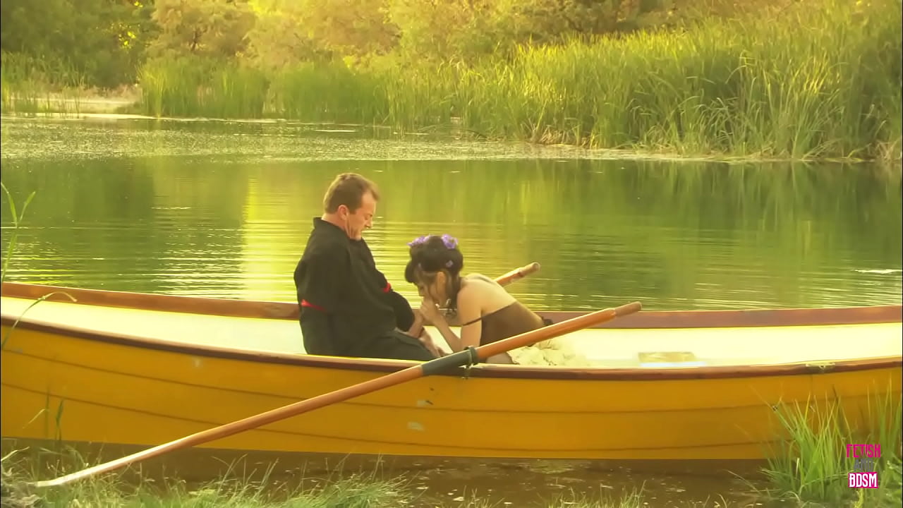 In the midst of a lake, a charming pair engaged in an outdoor activity on a compact watercraft