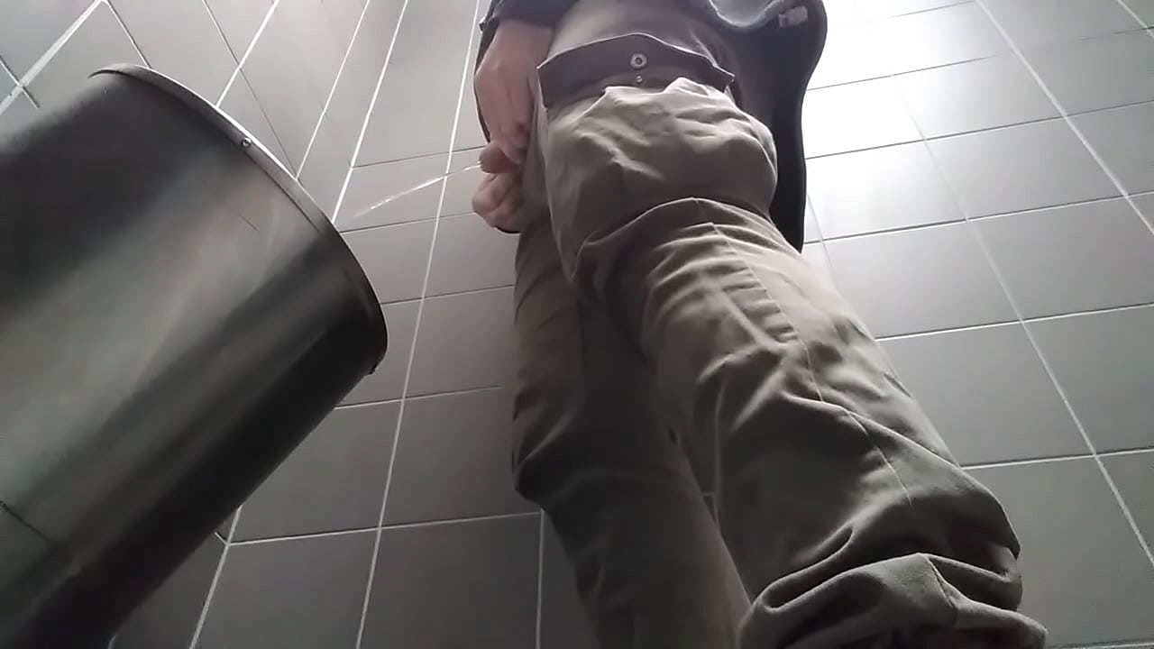 Uncut man peeing in a public toilet.