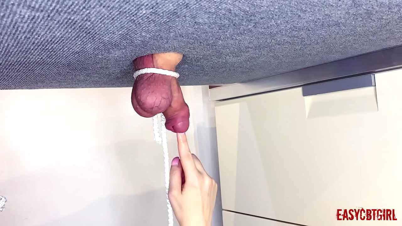 Slutty tied balls and pokes in very small cock with a finger on the milking board