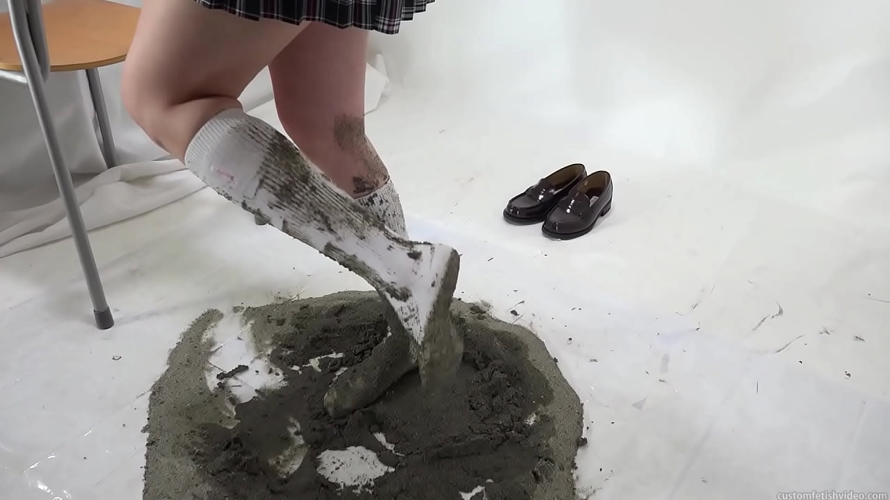 girl soiling her clean new socks with sand.