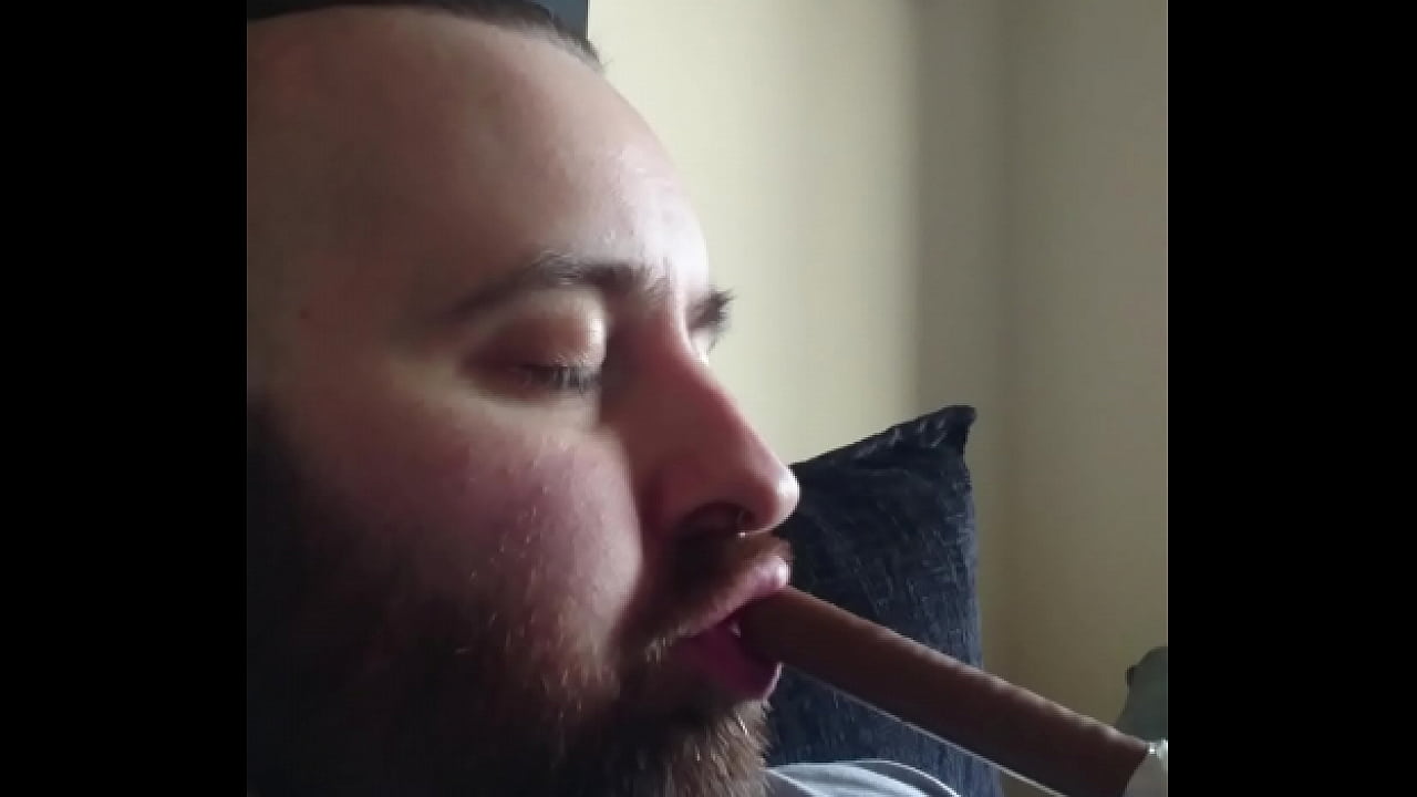 Hot bearded guy gagging on chocolate bar.