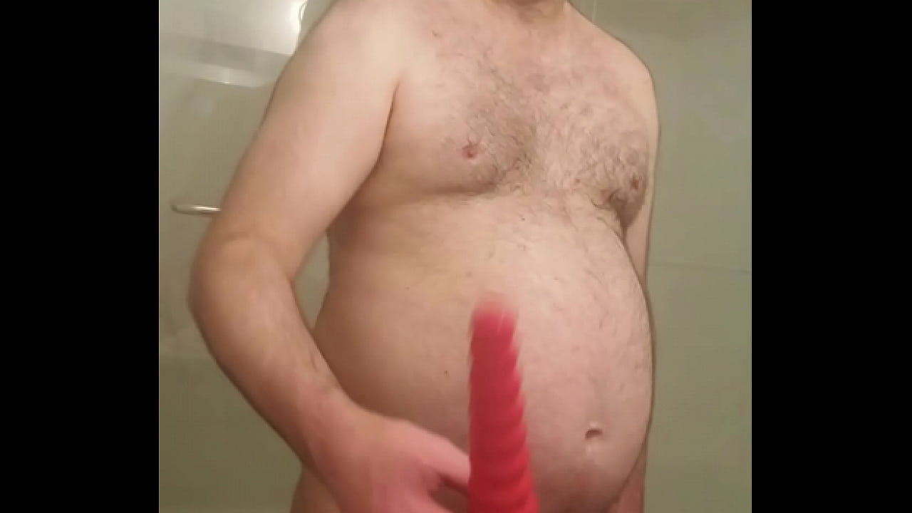 Naked Martin Lavallée fucks himself by the means of a red gode & juxtaposes it beside his black cock cage