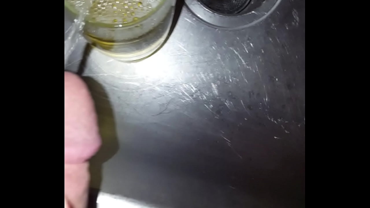 Strong golden piss into a cup