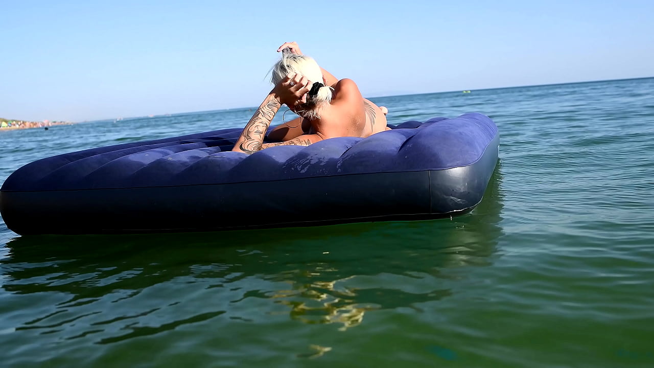 I spy on the beach as a girl with big boobs sunbathes in front of the public and dolphins