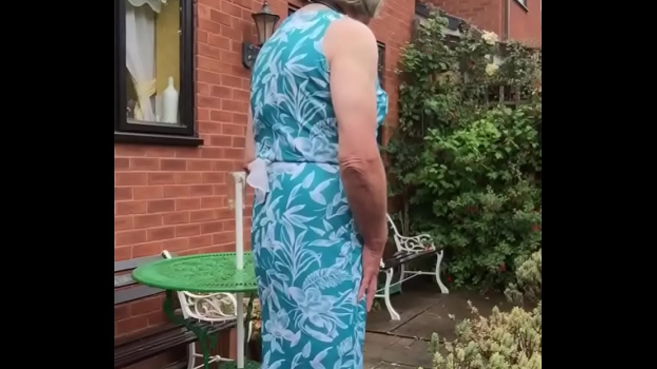 Johanna poses outdoors in green dress & white boots in garden