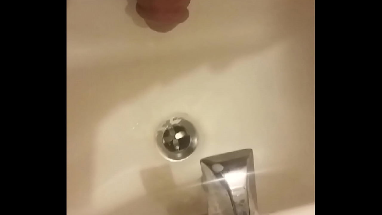 Guy peeing in sink by himself