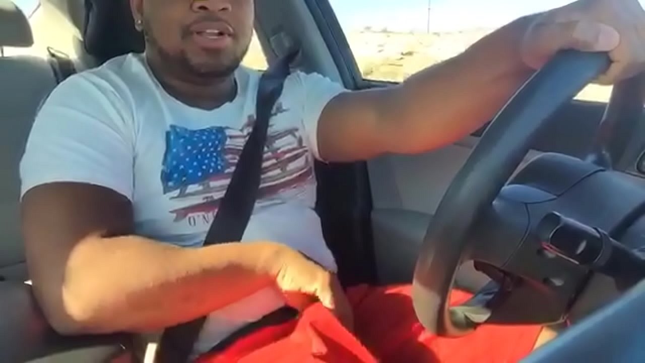 Thug milks his Big Black Cock behind the wheel.