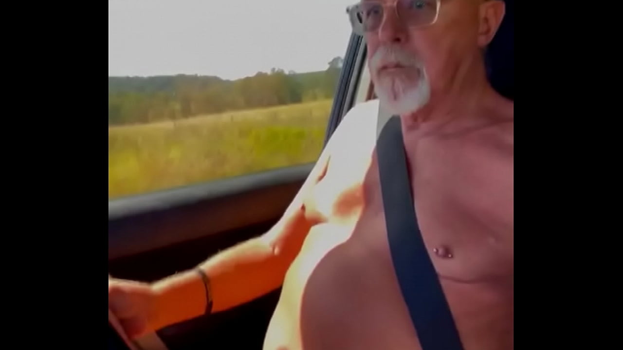 Nude male driving naked with an erection.