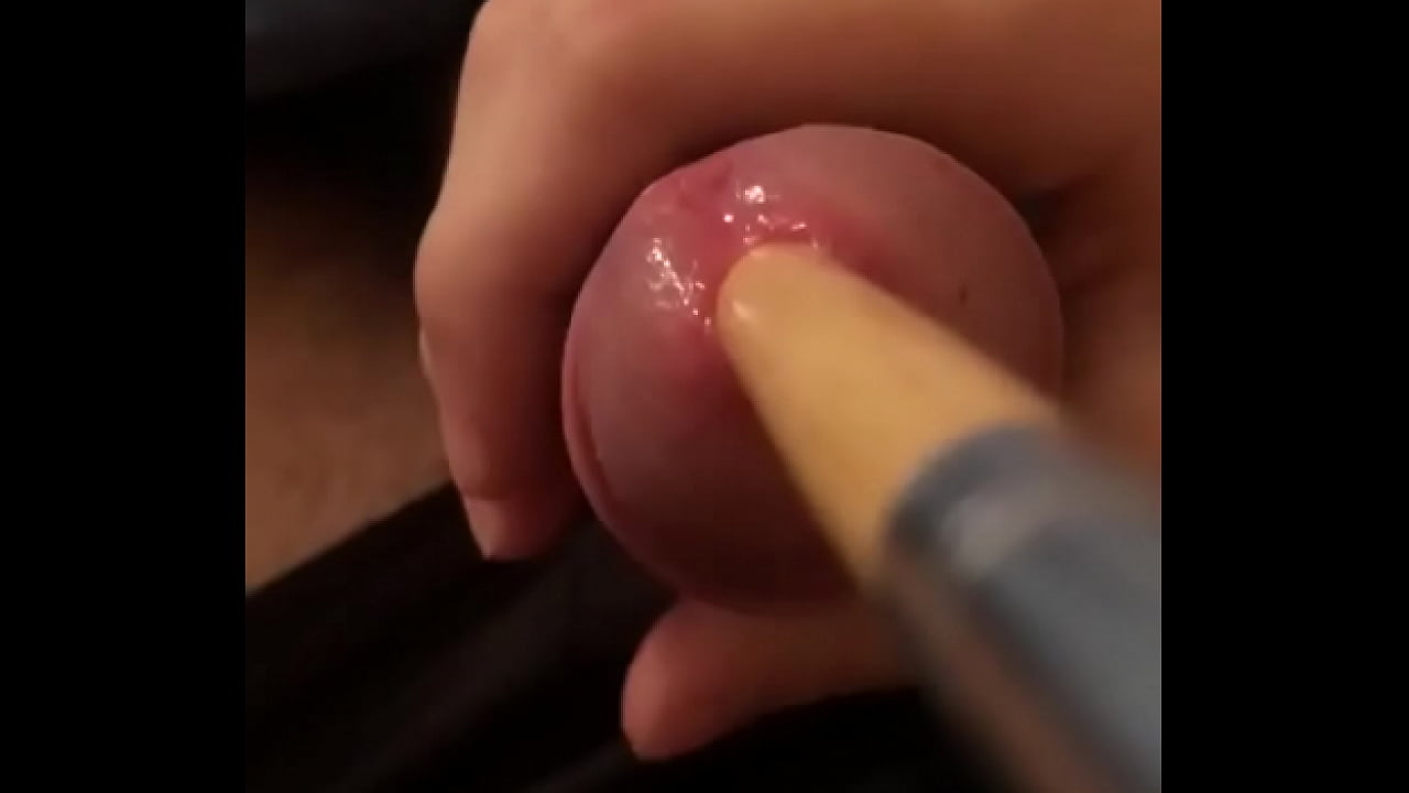 Inserting long wooden brush in cock