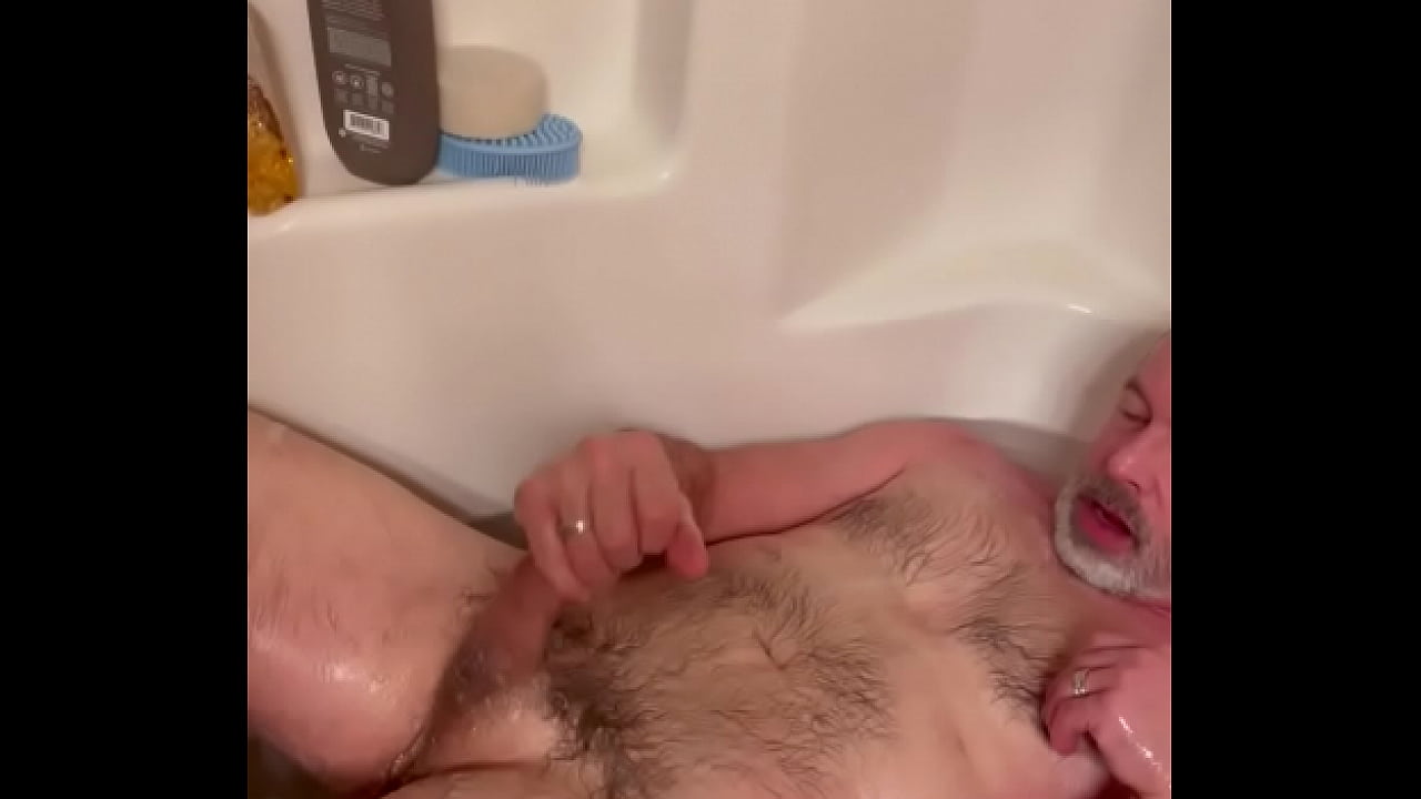 Sexy is in the tub, soaking takes his soft penis to a hard throbbing cock