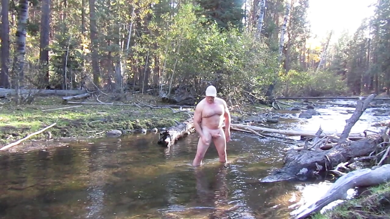 Stroking my cock in the creek.