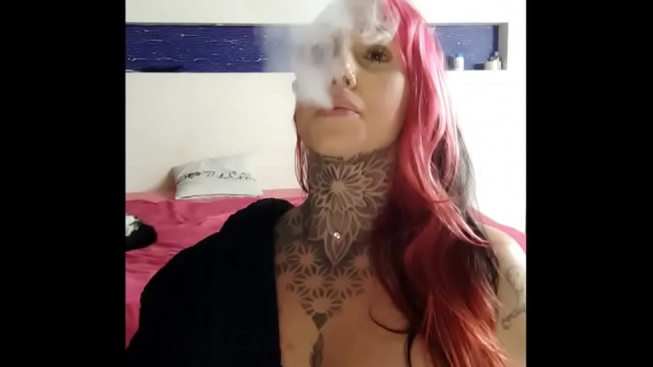 Brasileira tatuada realizando smoking fetish