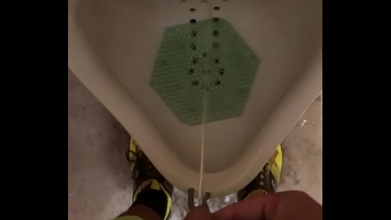 Male pisses in a urinal and thumbs dick