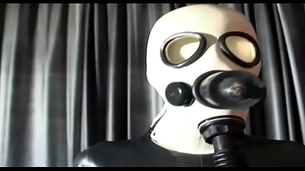 A hot slut in latex and gas mask, tastes some dildos in her mouth